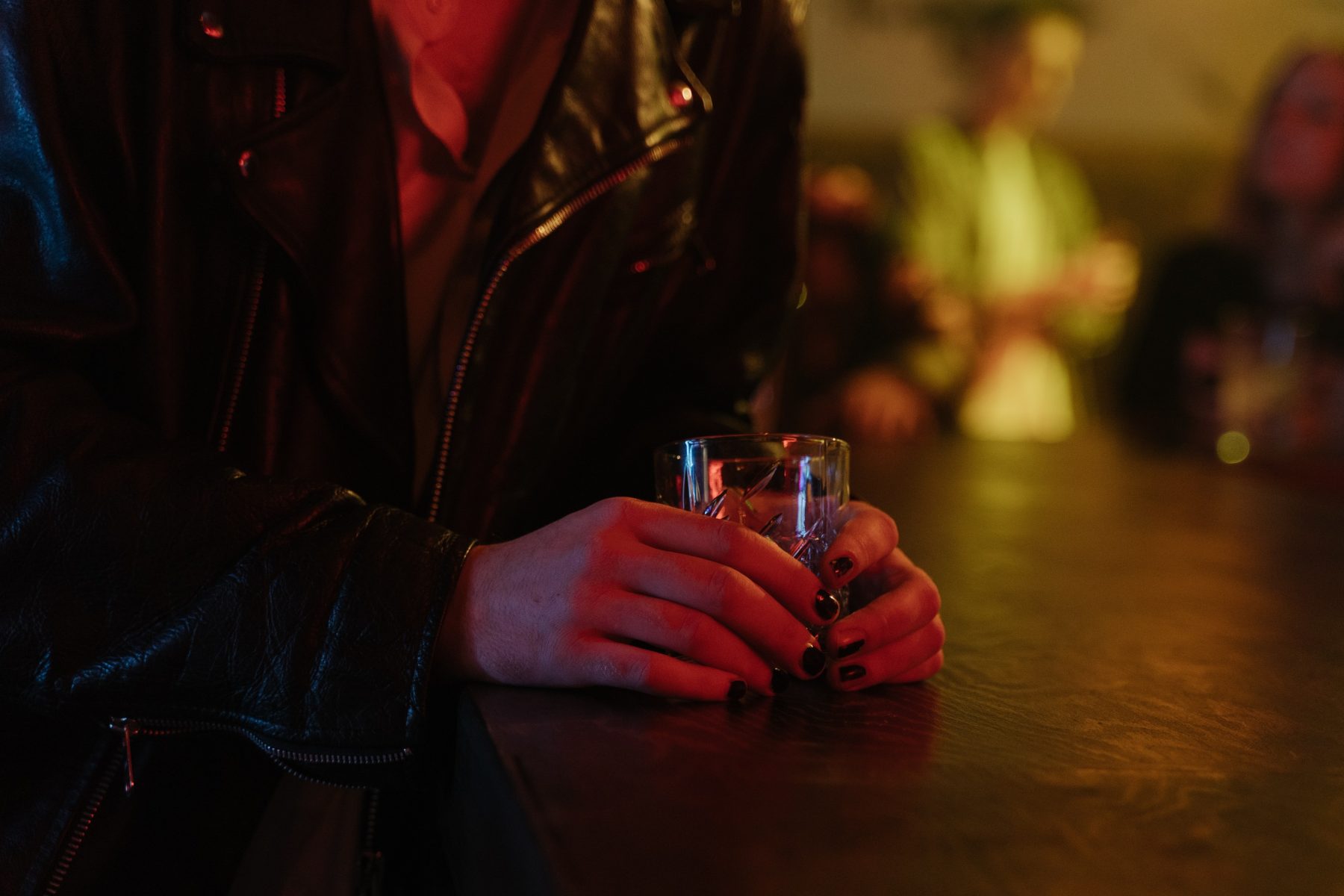 A person holding a cup of an alcoholic drink.