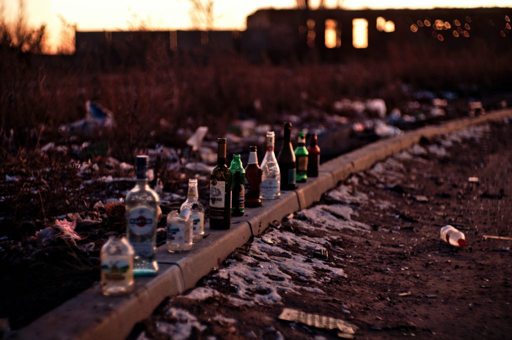 Alcohol bottles lined up on the pavement.