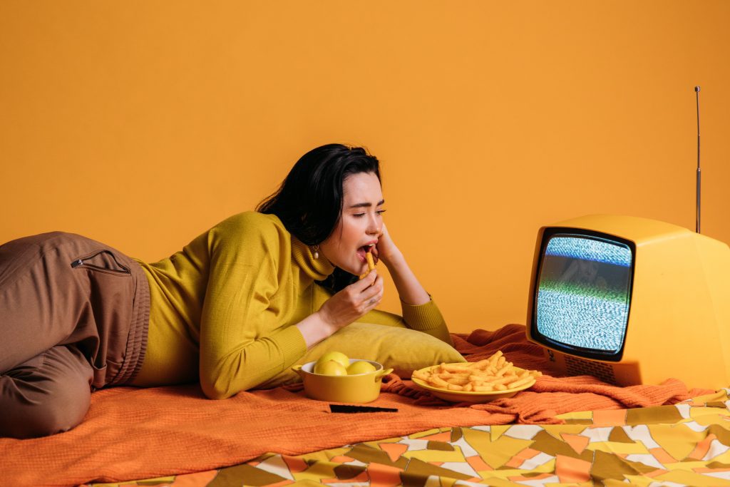 A woman binge eating while she watched a show.