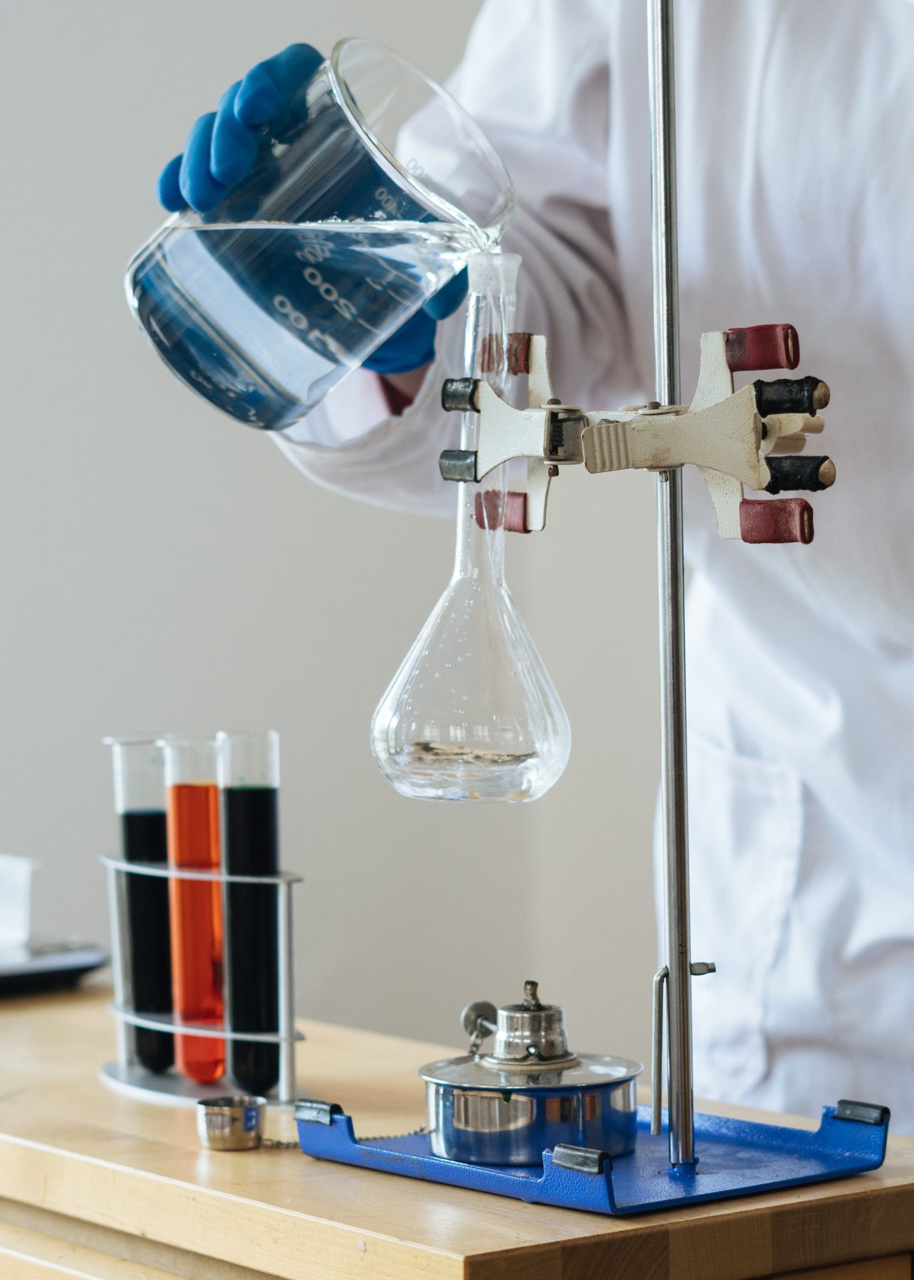 A scientist mixing two liquids with tubes next to him, biochemical process.