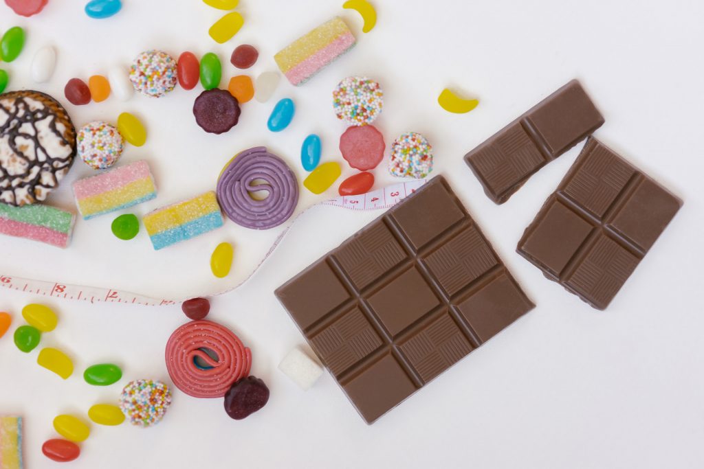 Candy, measuring tape, and chocolate bars with a white background.