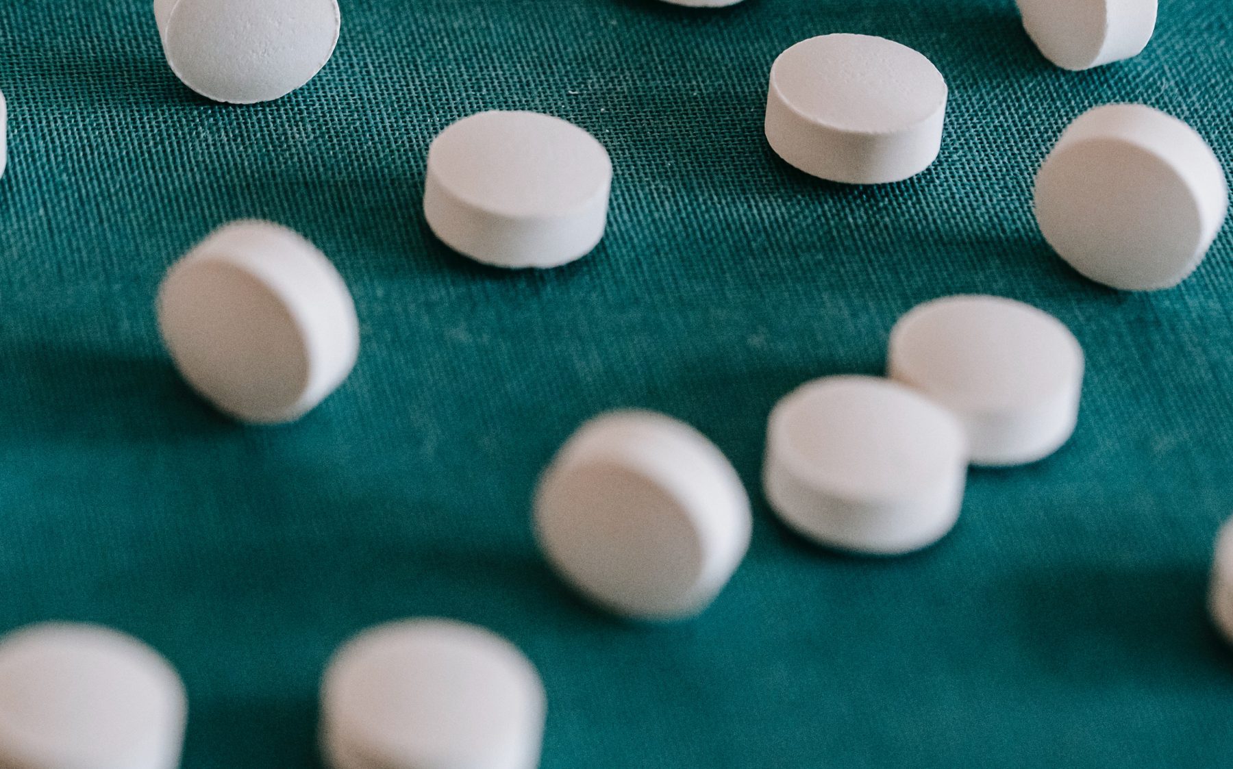 White pills on a green background.
