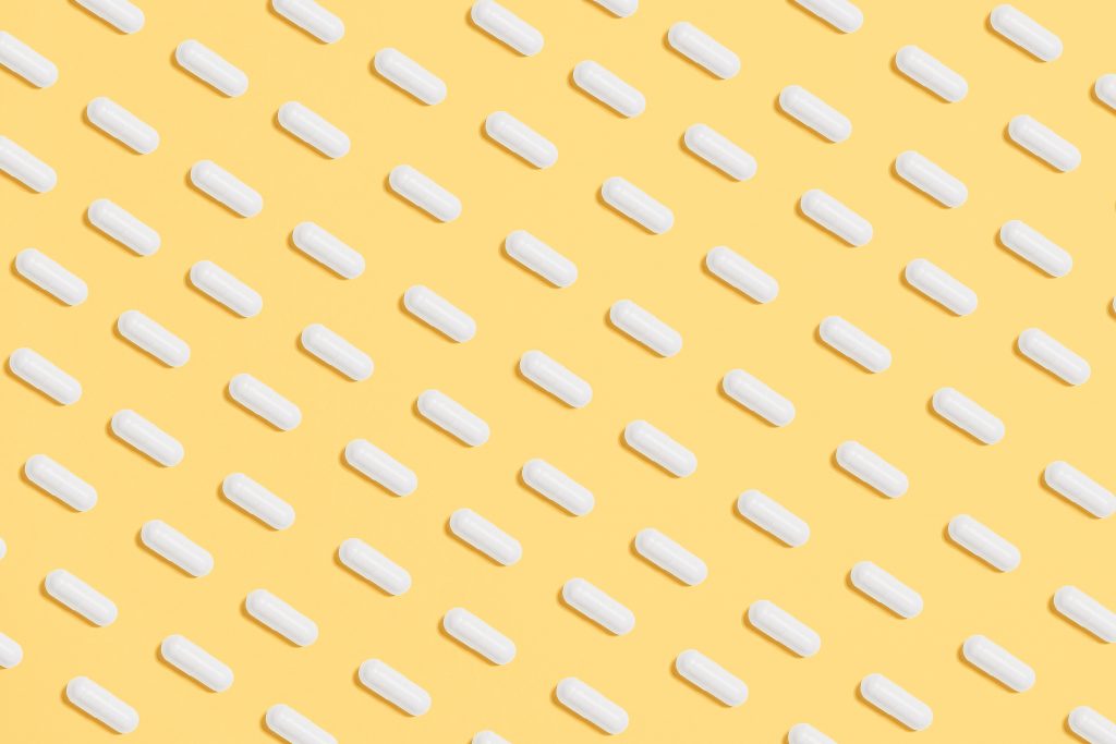 White pills arranged on a yellow background.