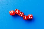 Dice cubes in red that spell the word 'panic' with a blue background.