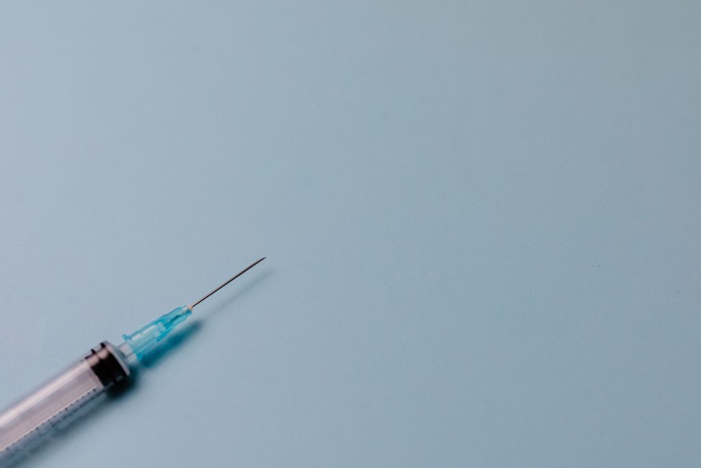 A picture of a syringe with a light blue background.