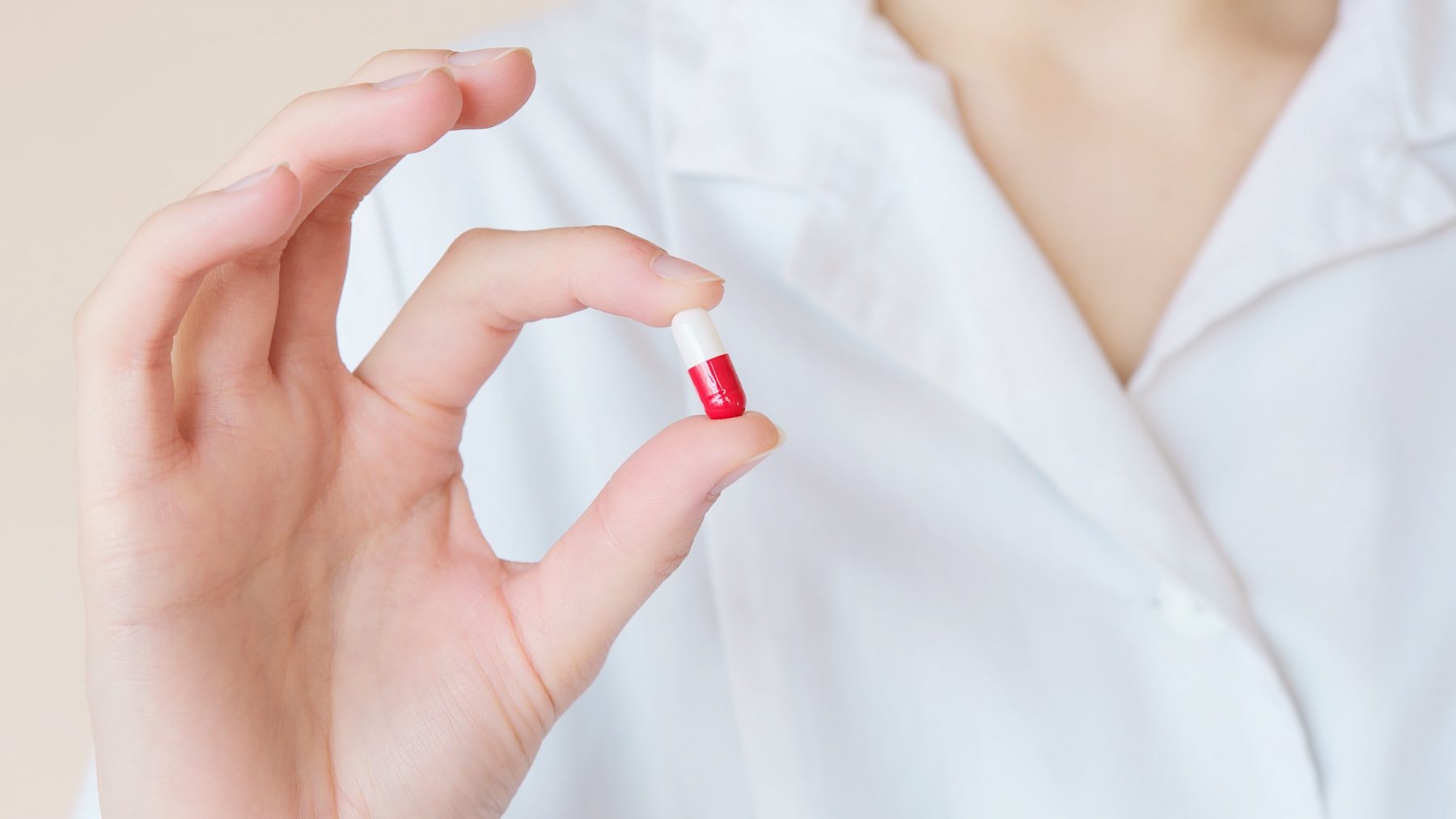 A person holding a pill in their hand.