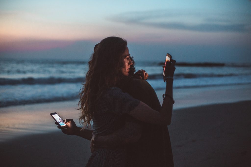 people hugging with phone in their hands
