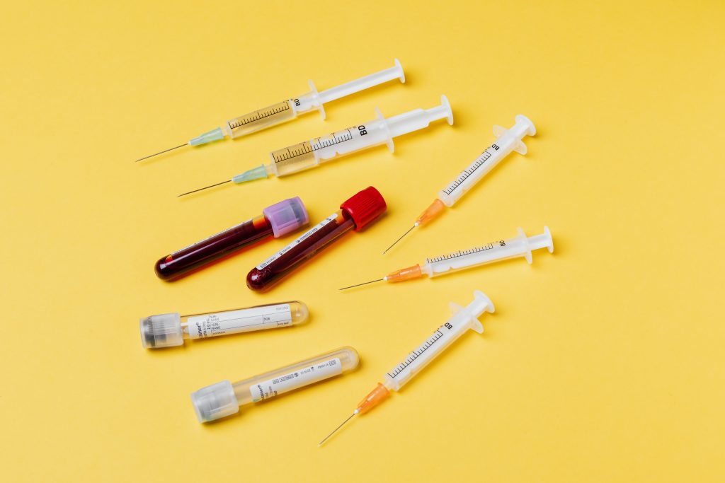 Syringes and tubes with a yellow background.